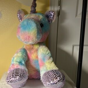 Unicorn by Kelly Toy, glass eye is amber and black. Horn is purple.